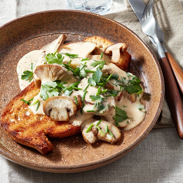 Sauterede svampe i en cremet sauce på surdejsbrød